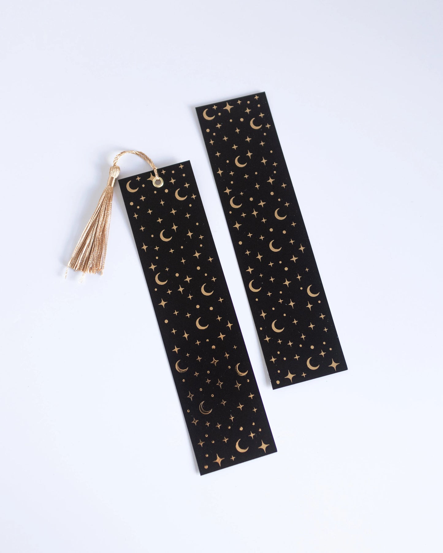 Marcador de página com padrão de estrelas e luas, dourado e preto