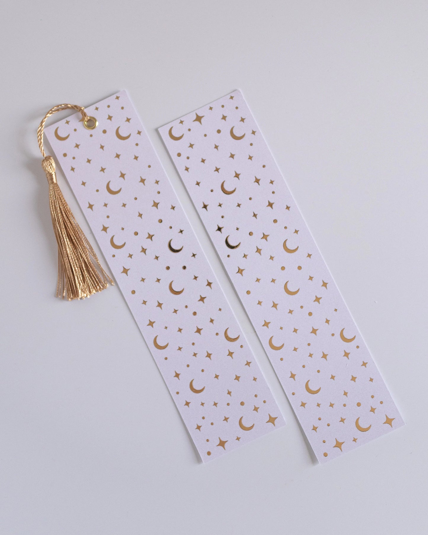 Marcador de página com padrão de estrelas e luas, dourado e branco