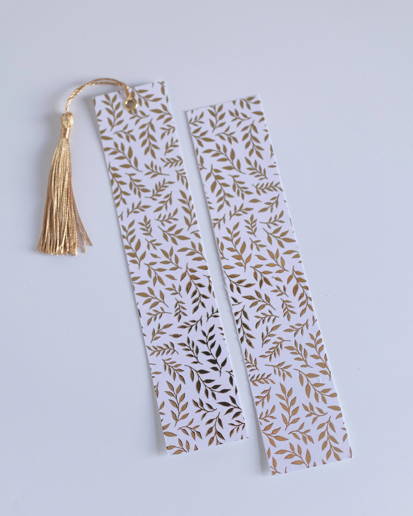 Marcador de página com padrão de folhas douradas e brancas